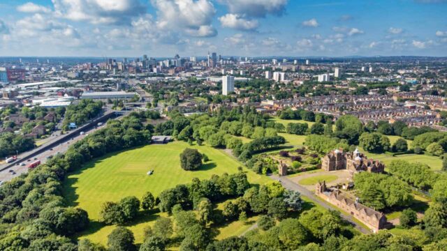 Aerial view of a large green space with a city in the background