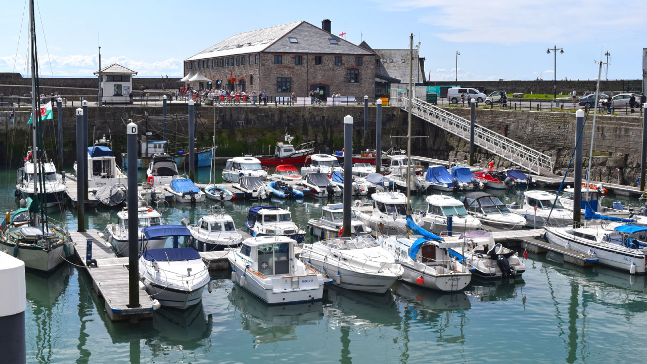 Stone warehouse by harbor with boats in foreground