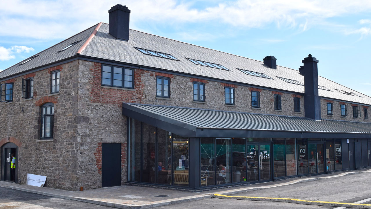 Side view of brick and stone building with skylights and awning