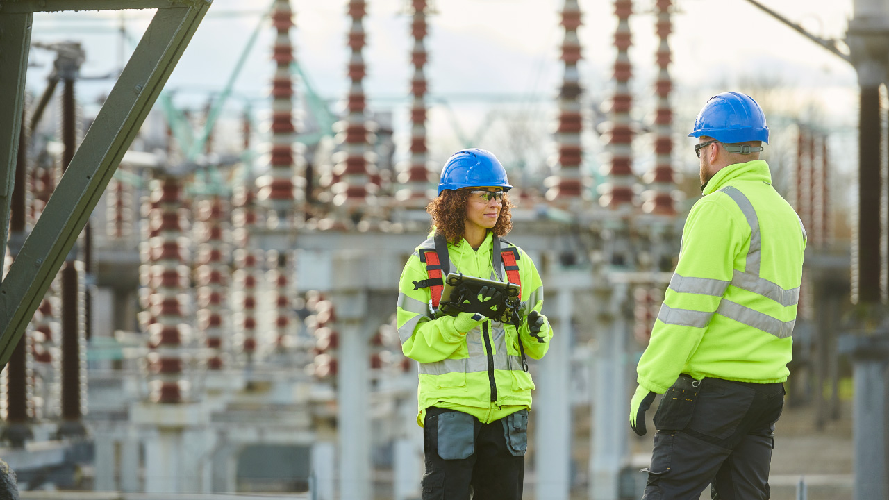 Two workers on site wearing high visibility protection and PPE