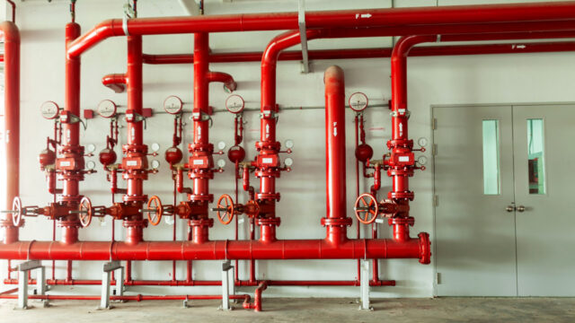 Lines of red fire safety pipes and pressure gauges