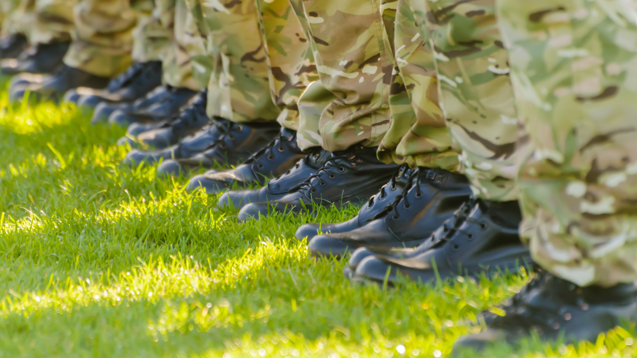 Uniformed pant legs and boots on grass