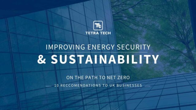 A glass building reaching for the sky with the words “Improving Energy Security & Sustainability on the Path to Net Zero“