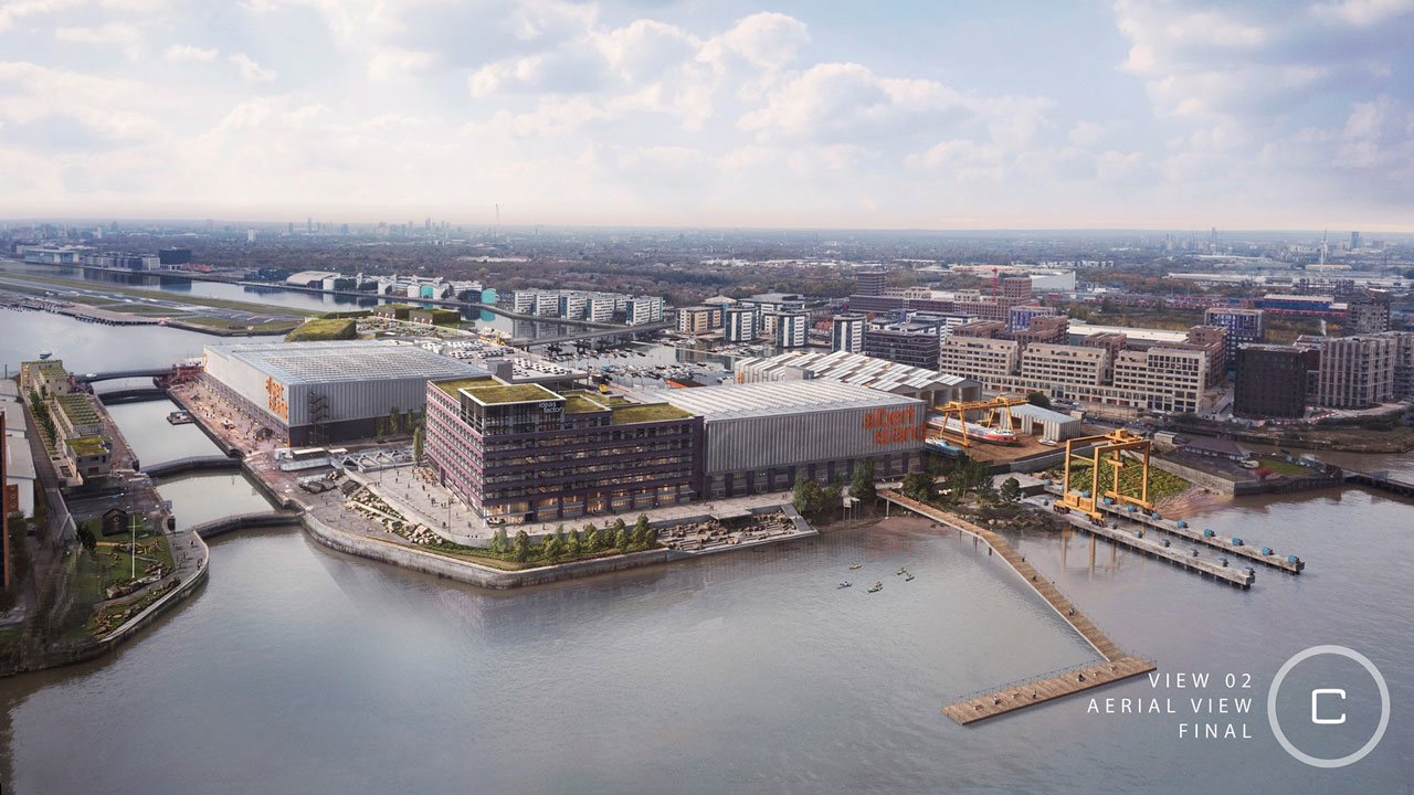 Wide aerial view of a large development structure sitting on the river with a dock that stretches out onto the water