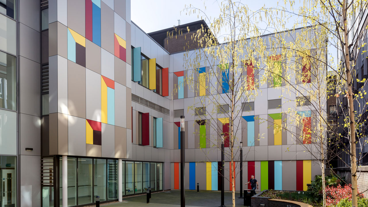 Exterior view of a courtyard overlooked by colorful hospital windows