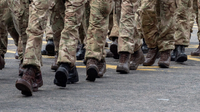 Uniformed pant legs and boots marching on the ground