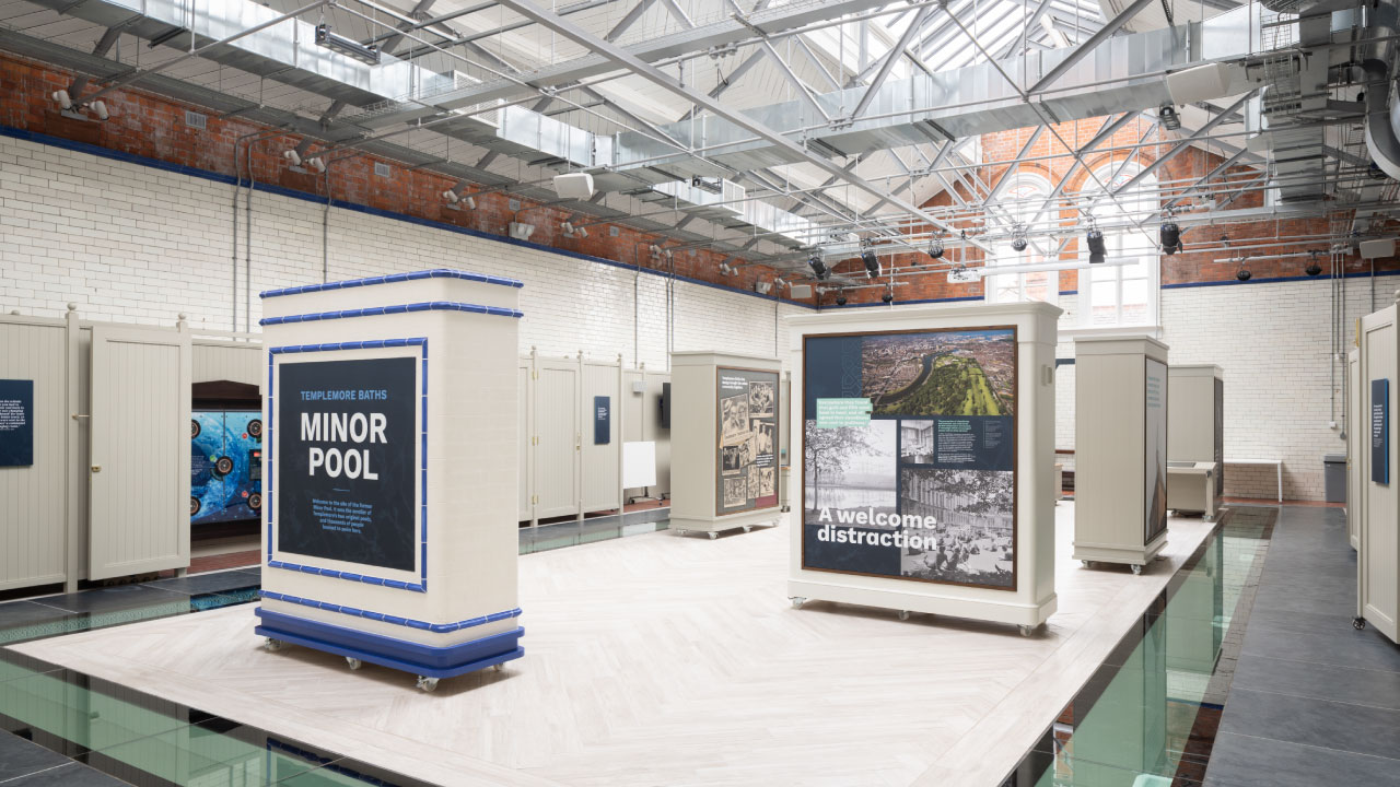 Interior room featuring signage and art on a white tile floor and open concept ceiling