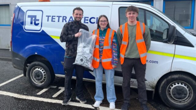 Tetra Tech team members stood in front of a Tetra Tech van in orange vests